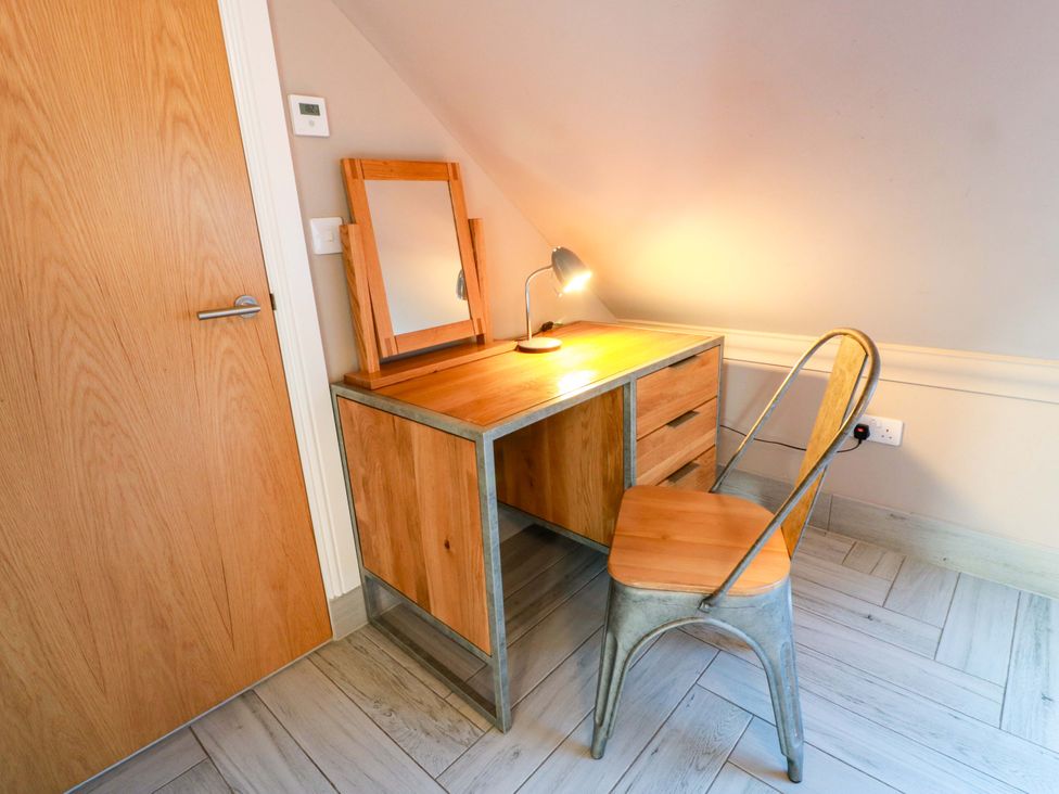 An office with a desk, mirror, lamp and chair at Ledrishmore View, Alexandria