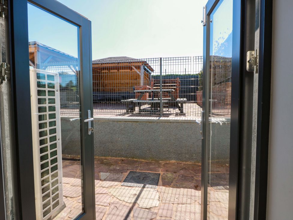 An outdoor patio with a fenced area and seating at Ledrishmore View in Alexandria
