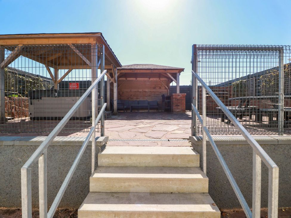 An outdoor patio with seating and a wooden structure at Ledrishmore View in Alexandria