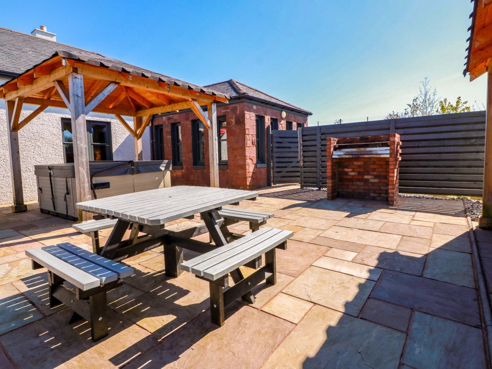 An outdoor area with a table and benches at Ledrishmore View in Alexandria