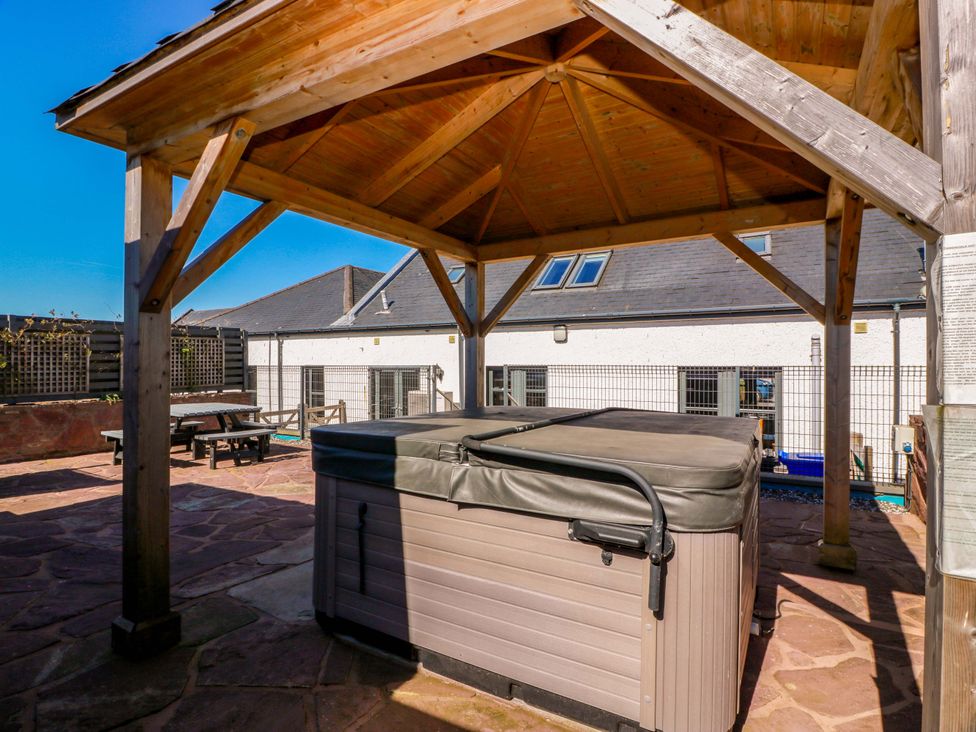 An outdoor area with a hot tub and wooden gazebo at Ledrishmore View Alexandria