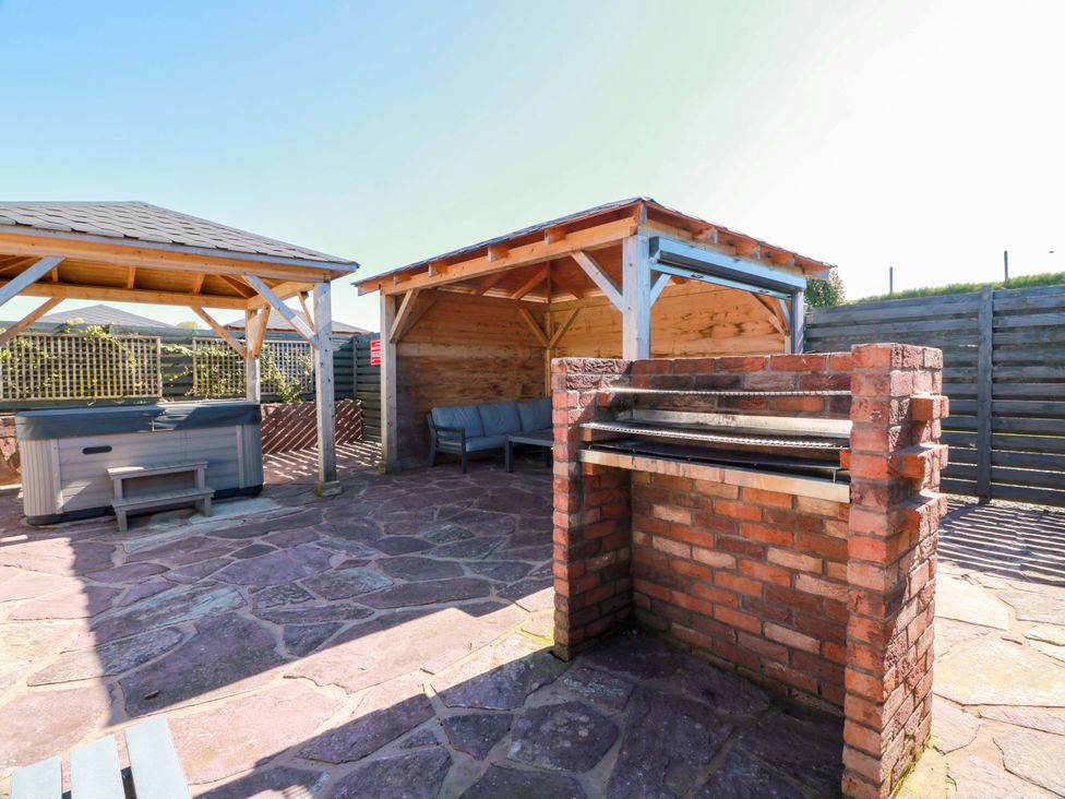 An outdoor area with a barbecue, hot tub and seating at Ledrishmore View, Alexandria