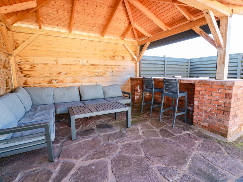 An outdoor seating area with a sofa and bar at Ledrishmore View in Alexandria