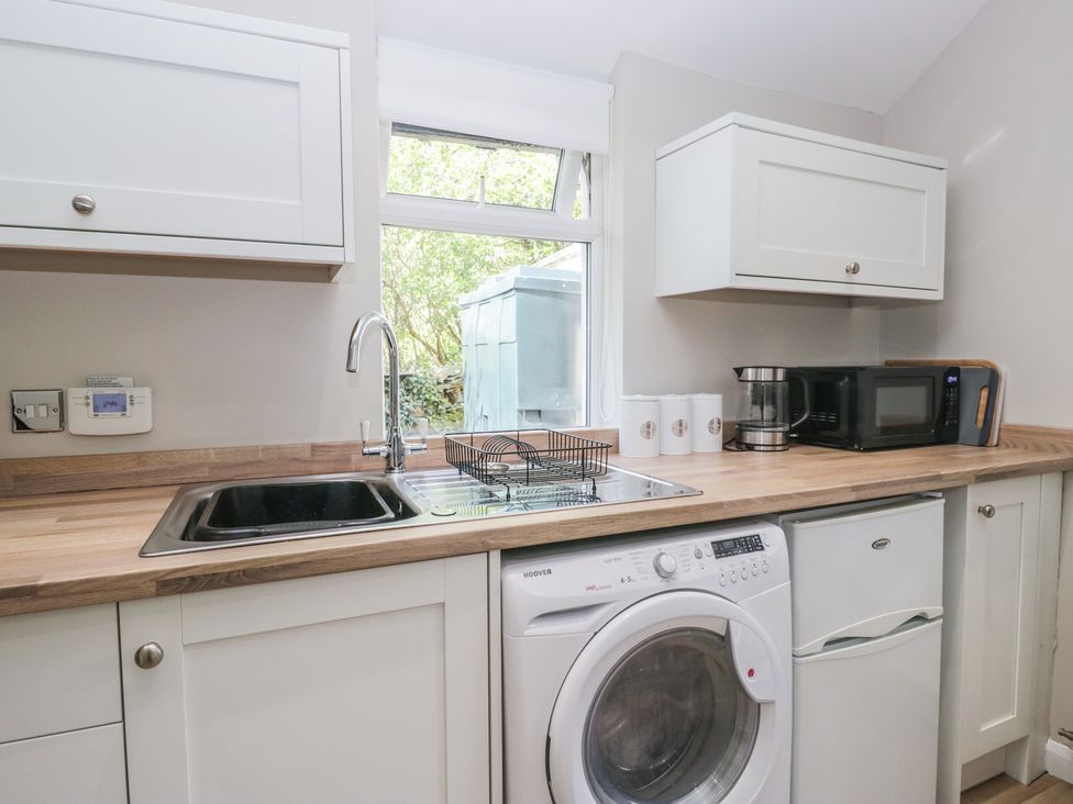 A kitchen with a sink and washing machine at Fellfoot Cottage