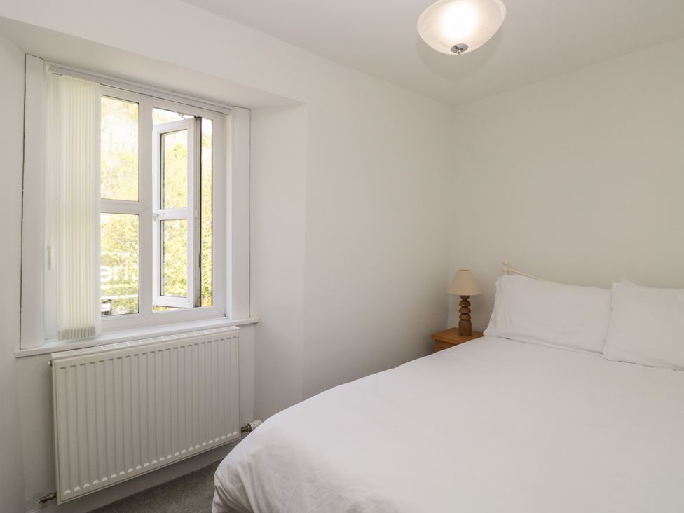 A bedroom with a bed and a lamp at Fellfoot Cottage in 