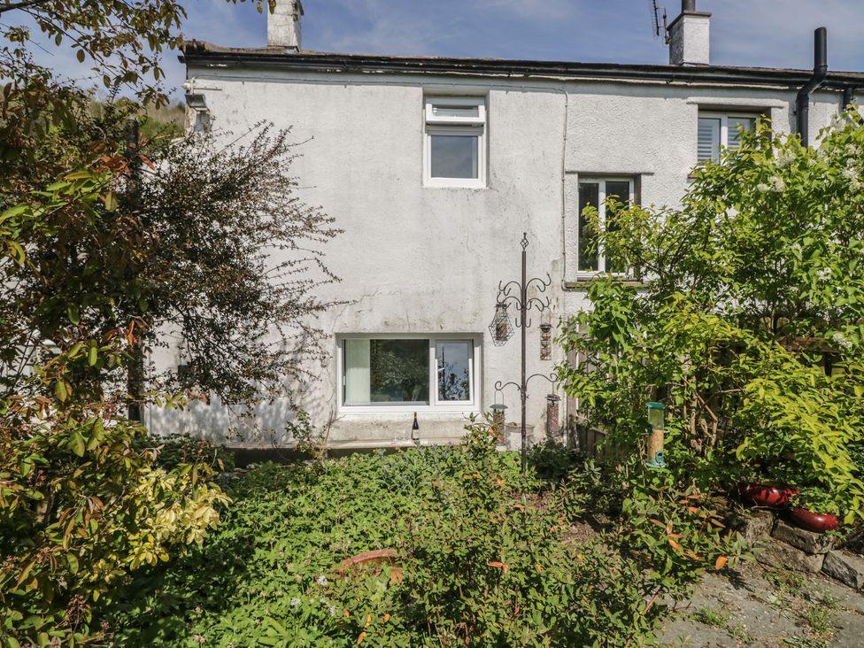 A house with a garden and bird feeders at Fellfoot Cottage