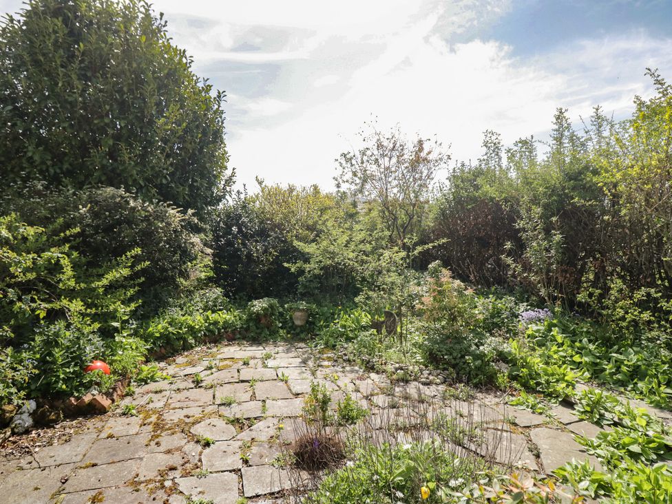 A garden area with stone paving and various plants at Fellfoot Cottage