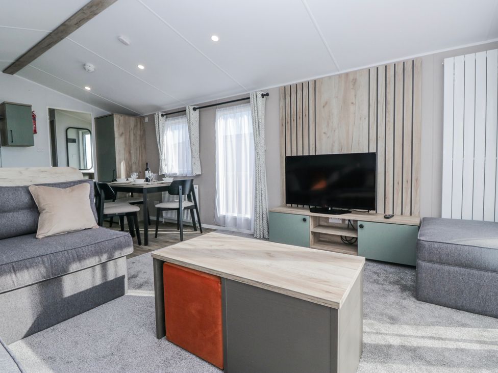 A living room with a sofa, table, chairs, and television at Willerby High End Brand S6 (on Coniston) St Bees