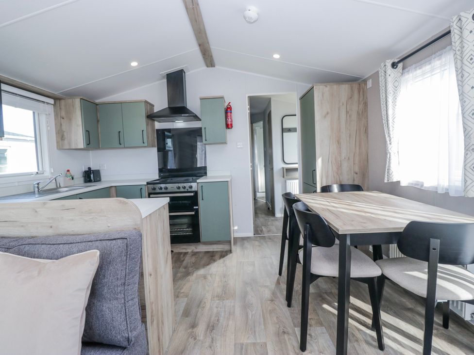 A kitchen with a table and chairs at Willerby High End Brand S6 (on Coniston) St Bees