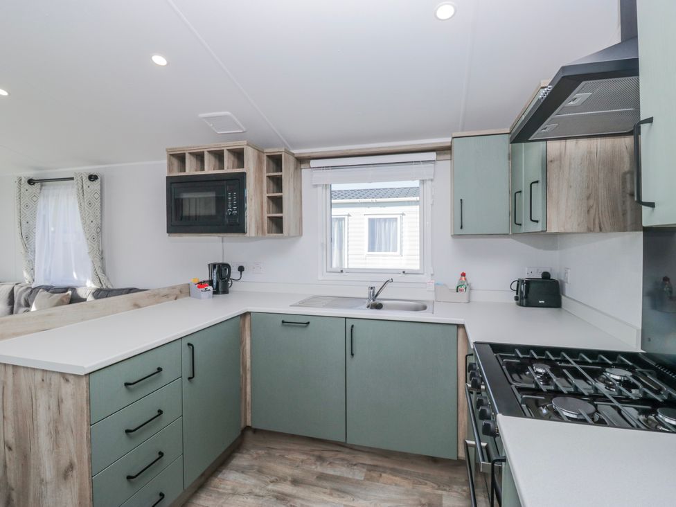 A kitchen with a microwave and cooking stove at Willerby High End Brand S6 (on Coniston) St Bees