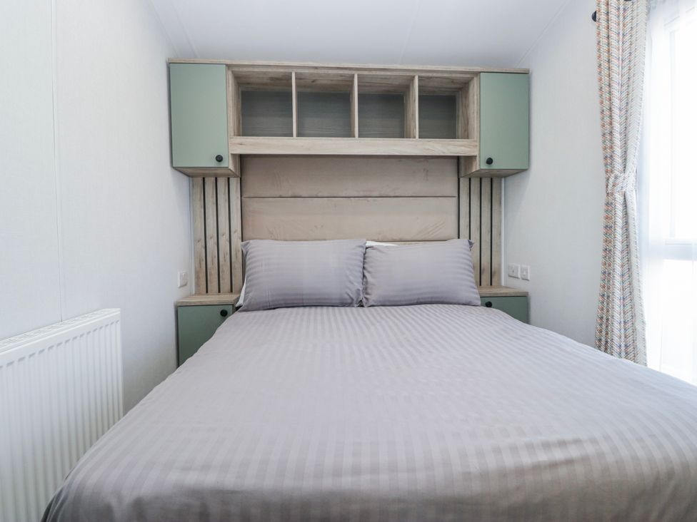 A bedroom with a bed and shelves at Willerby High End Brand S6 (on Coniston) St Bees