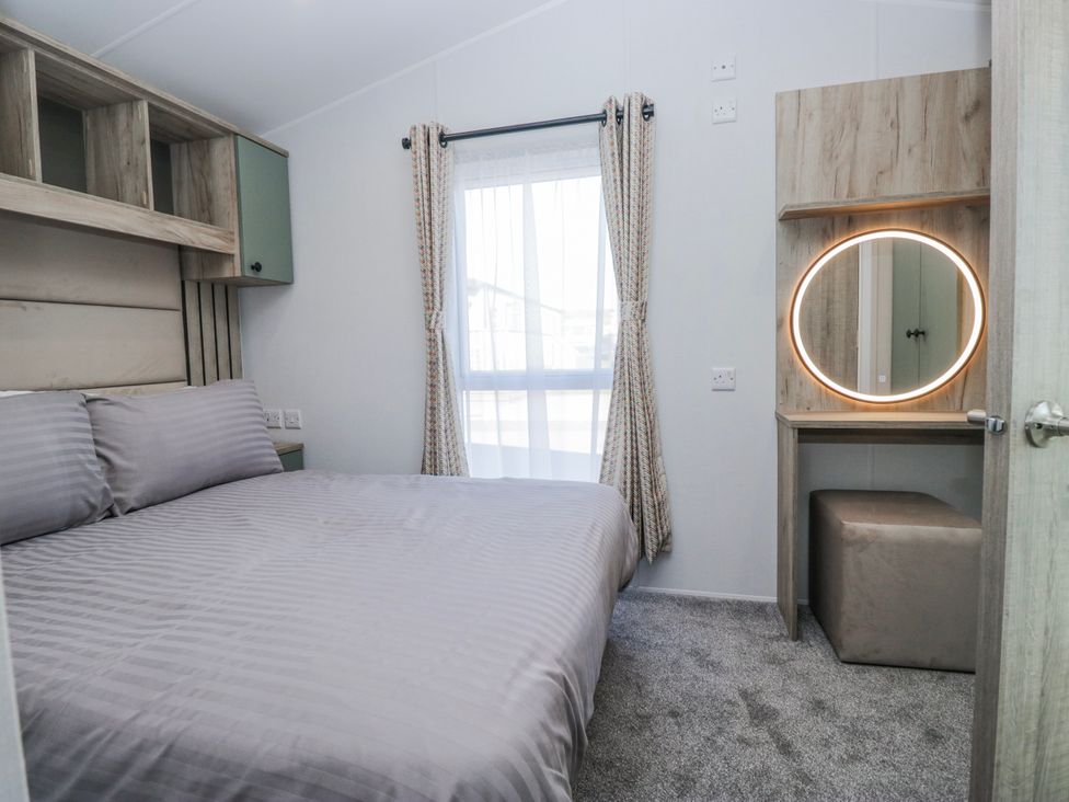 A bedroom with a bed and dressing table at Willerby High End Brand S6 (on Coniston) St Bees