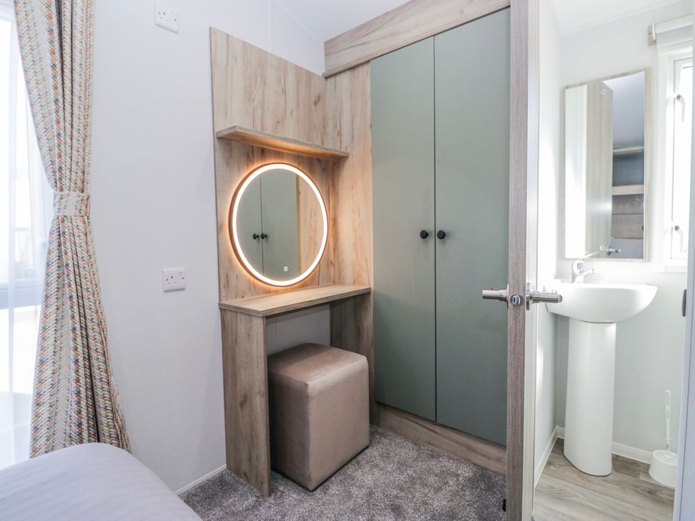 A bedroom with a vanity unit and wardrobe at Willerby High End Brand S6 (on Coniston) St Bees