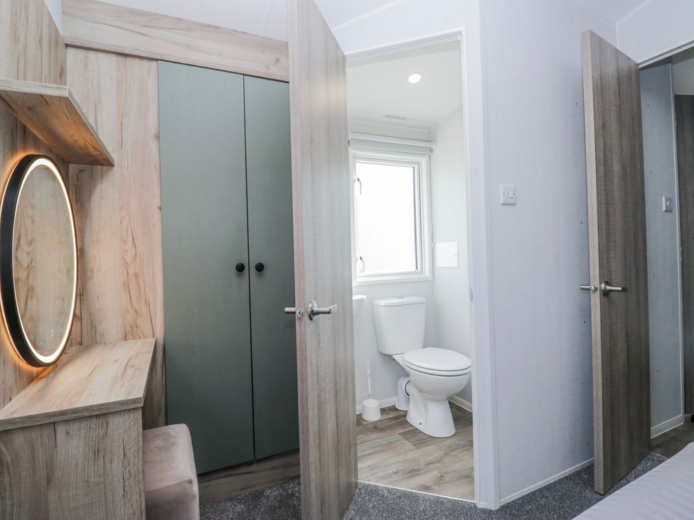 A bathroom with a toilet and a wardrobe at Willerby High End Brand S6 (on Coniston) St Bees