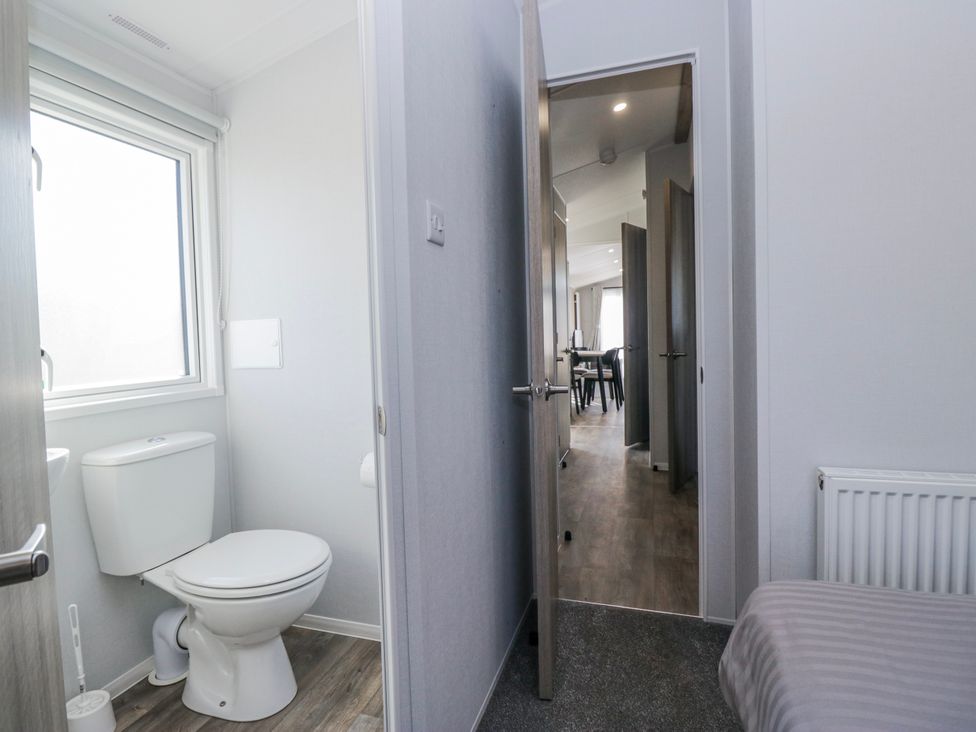 A bathroom with a toilet and window at Willerby High End Brand S6 (on Coniston) St Bees