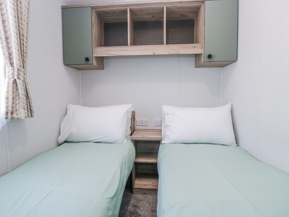 A bedroom with two single beds and a shelf at Willerby High End Brand S6 (on Coniston) St Bees