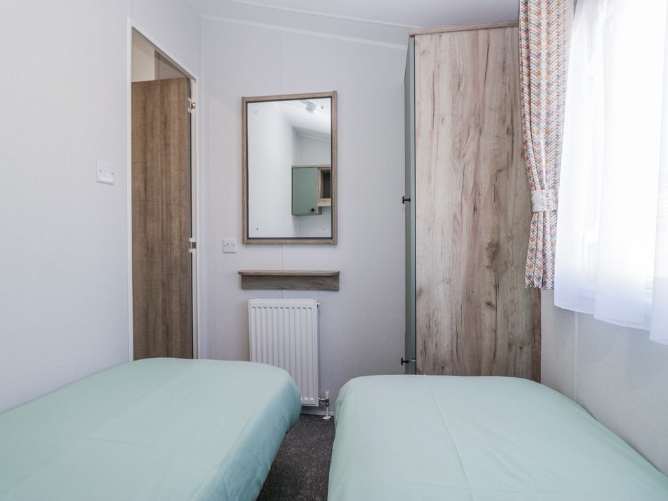 A bedroom with two beds and a mirror at Willerby High End Brand S6 (on Coniston) St Bees