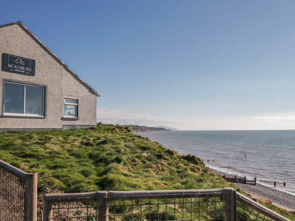 A house near the sea with a sign and a fence at Beach Road in St Bees