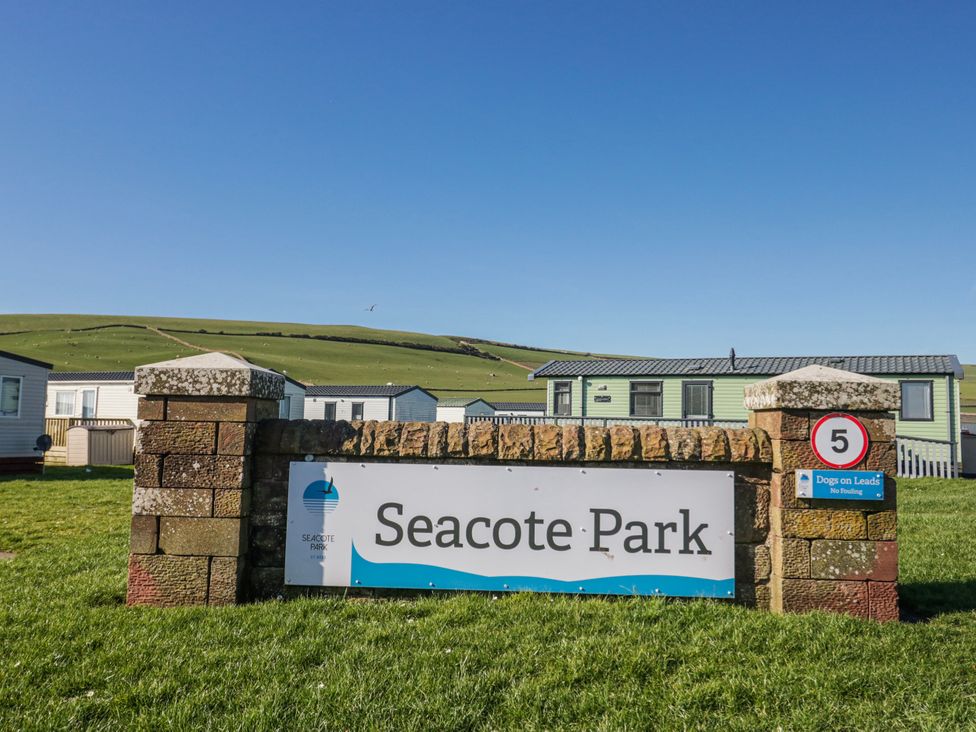 A sign for Seacote Park with caravans in the background at Seacote Park in St Bees