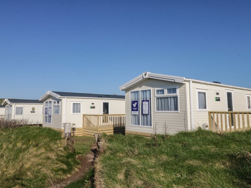 A view of holiday homes with grass and a pathway at Swift Brand (HOTEL SIDE) S4, St Bees