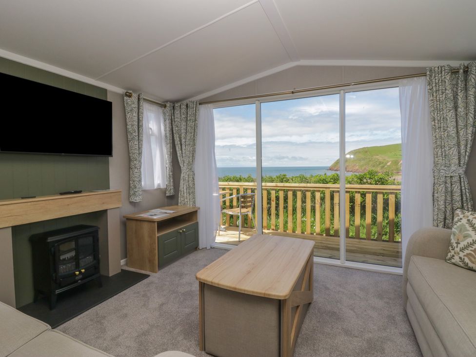 A living room with a view of the sea and hills at The Swift in St Bees