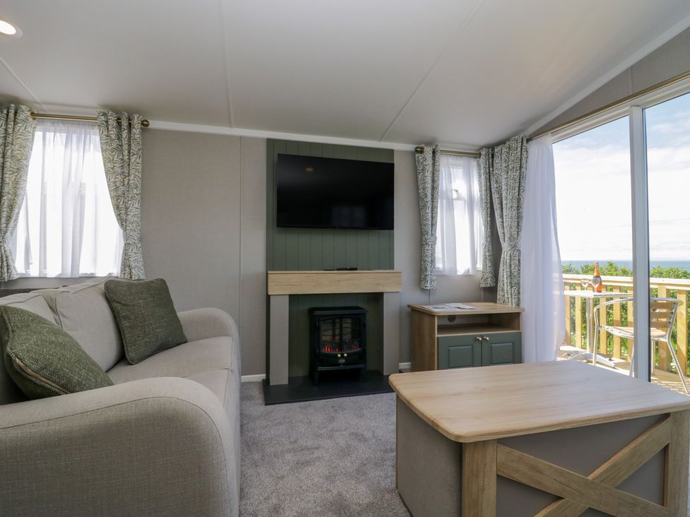 A living room with a sofa and fireplace at The Swift in St Bees