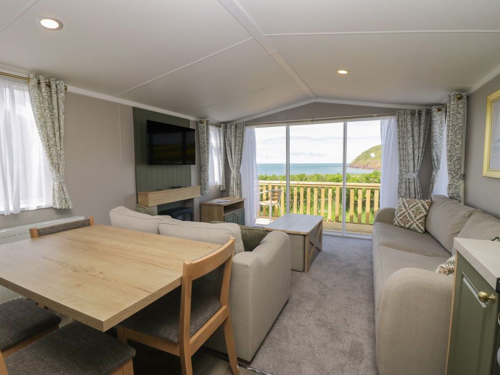 A living room with a dining table and sofa at The Swift in St Bees