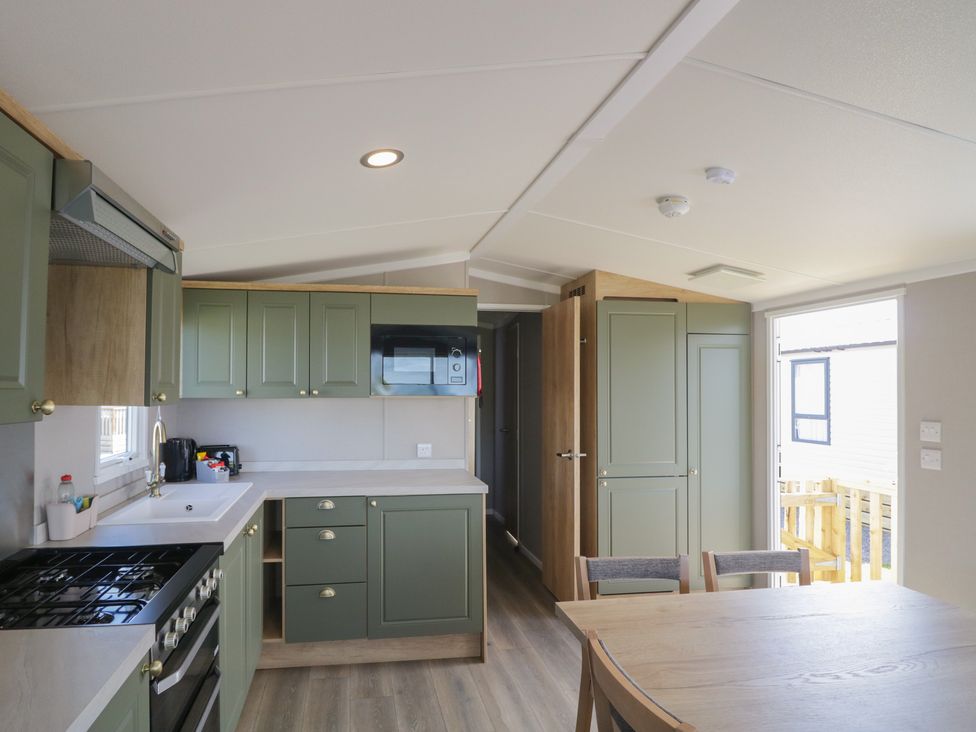 A kitchen with cabinets and appliances at The Swift in St Bees