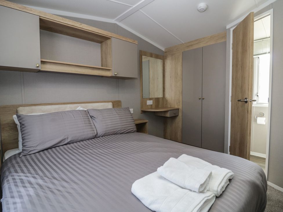 A bedroom with a bed and cabinets at The Swift St Bees