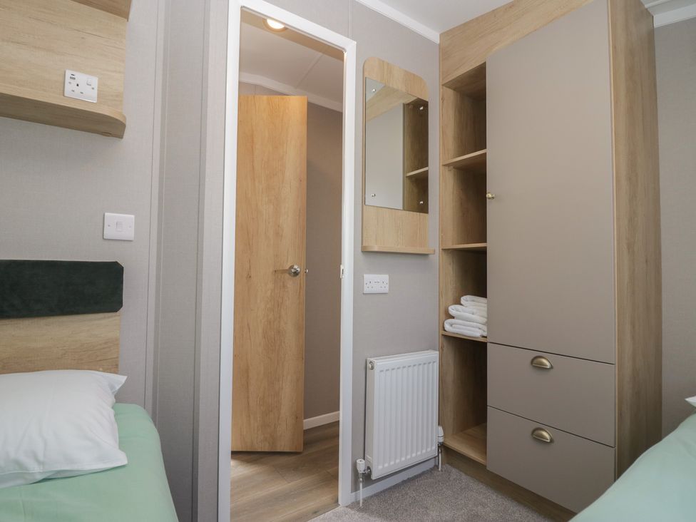 A bedroom with a bed and wardrobe at The Swift in St Bees