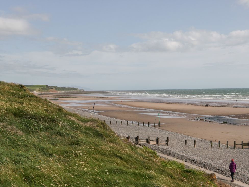 A beach with grass and people at Swift Brand (3 Bed) (on Coniston) St Bees