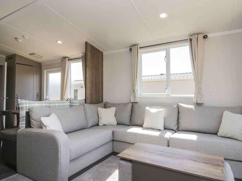 A living room with a sofa and coffee table at The Plover in St Bees
