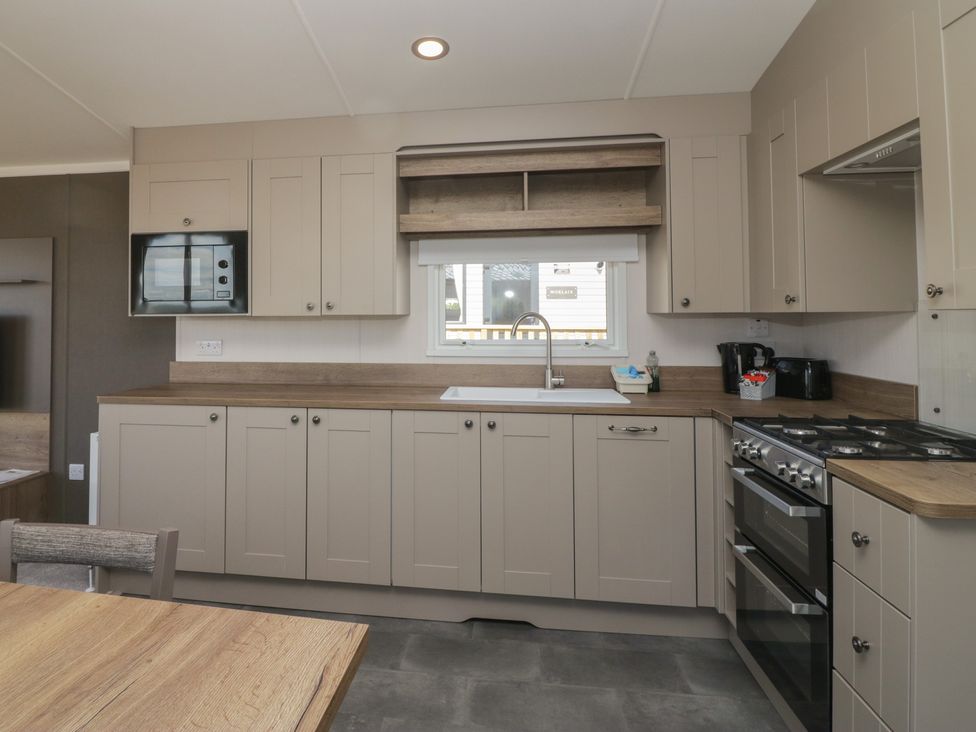 A kitchen with a microwave, sink, and cooker at The Plover in St Bees