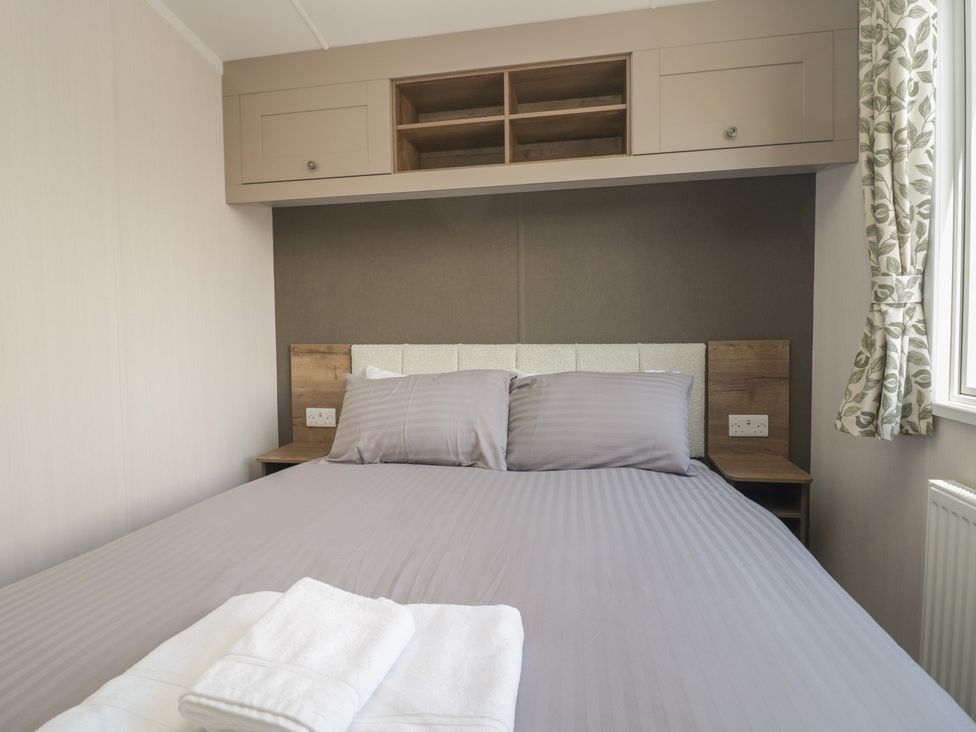 A bedroom with a bed and bedside table at The Plover in St Bees