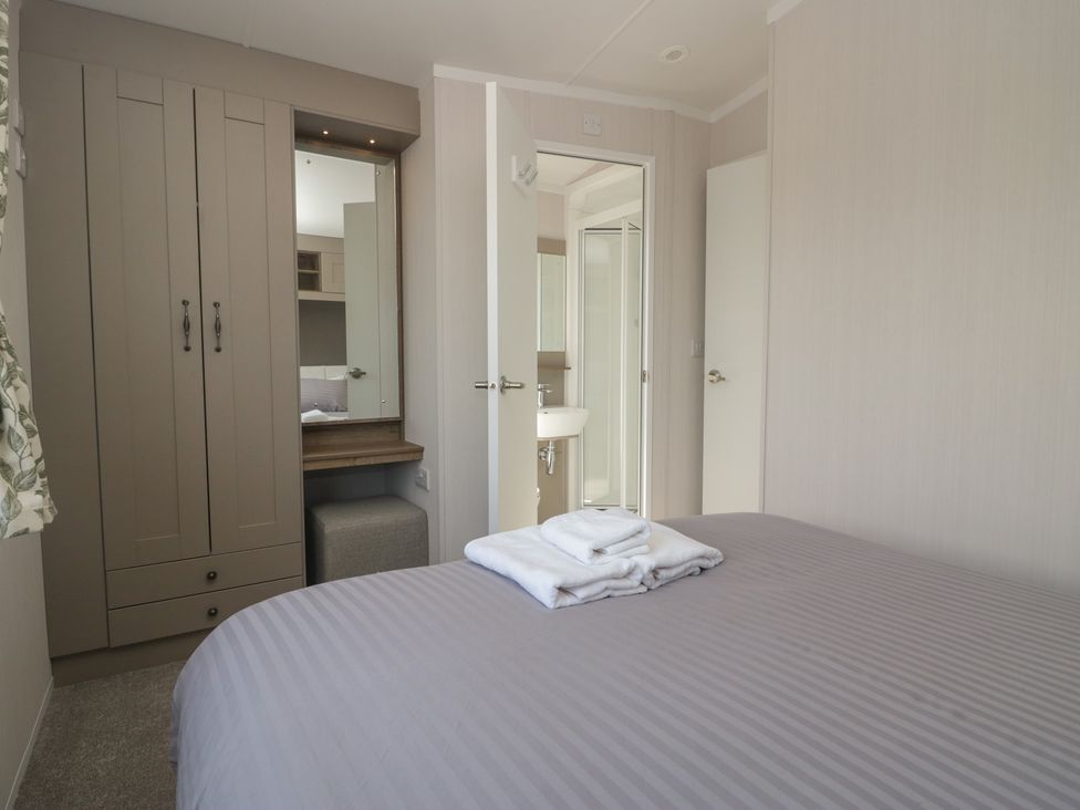 A bedroom with a bed and wardrobe at The Plover St Bees