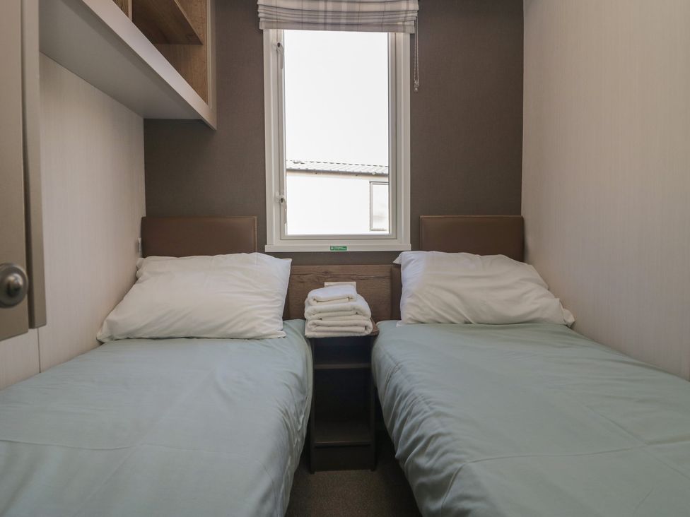 A bedroom with two beds and a window at The Plover in St Bees