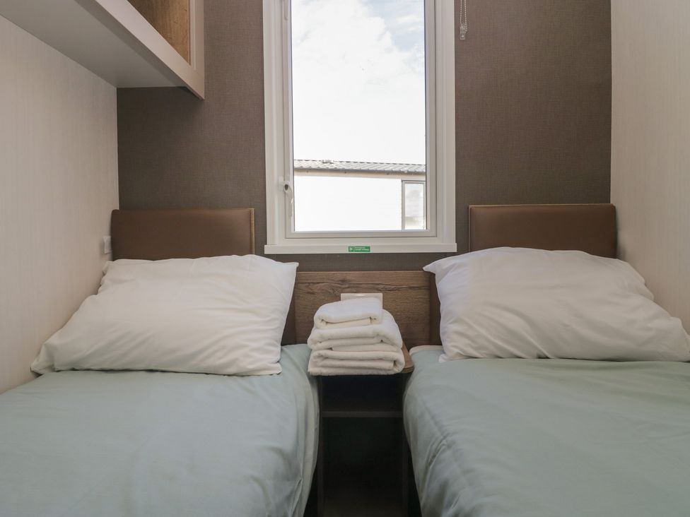 A bedroom with twin beds and a window at The Plover in St Bees
