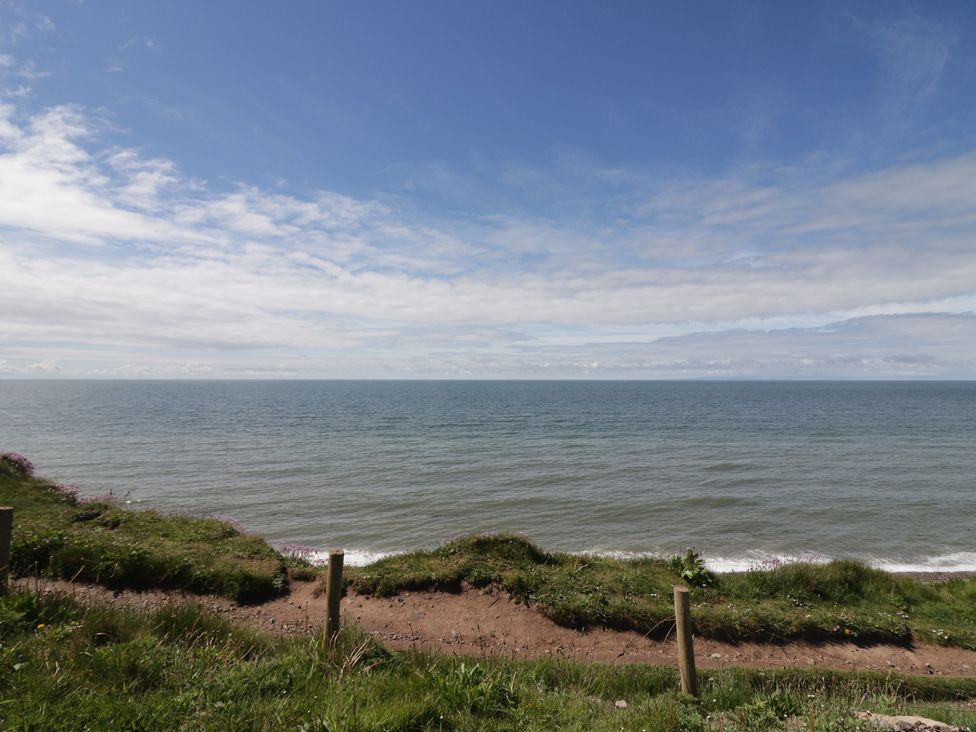 A coastal view with grass and a path at The Plover in St Bees