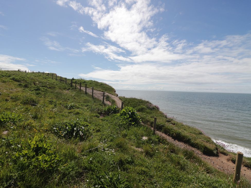 A coastal view with a pathway and fence at The Plover in St Bees