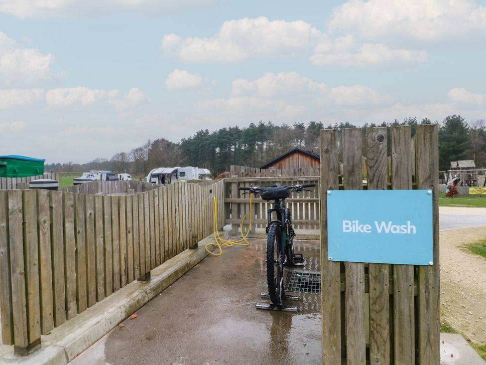A bike wash area with a bicycle and a sign at Sherwood - Cosy Pod 1