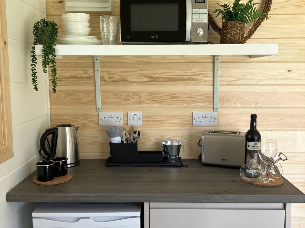 A kitchen area with a microwave, kettle, and toaster at Sherwood - Cosy Pod 1