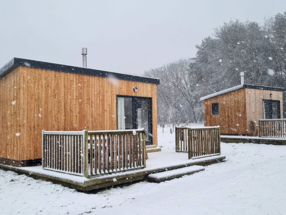 Two wooden cabins with snow on the ground at Sherwood - Cosy Pod 1