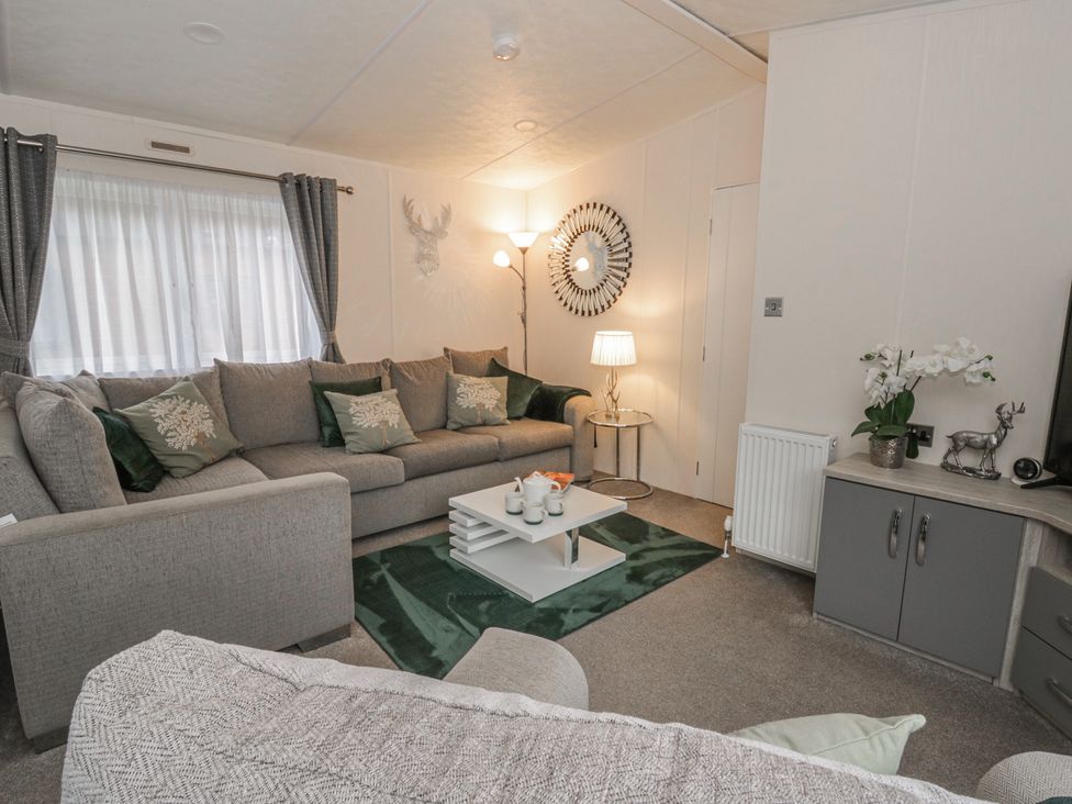 A living room with a grey sofa and a coffee table at The Ridgeway in New Quay