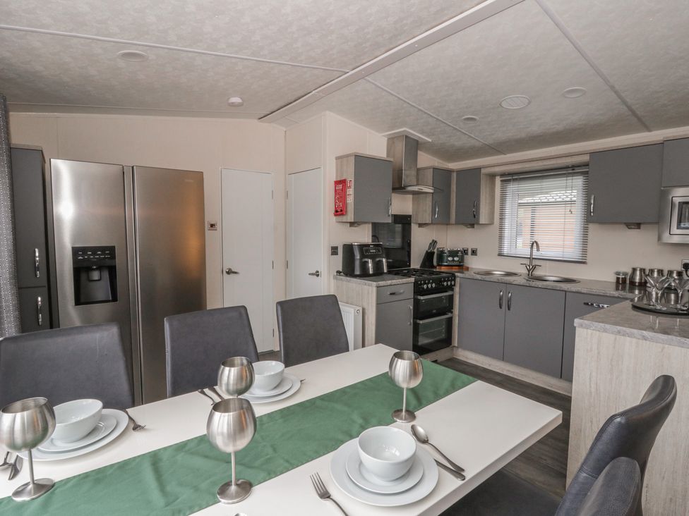 A kitchen with dining table and appliances at The Ridgeway in New Quay