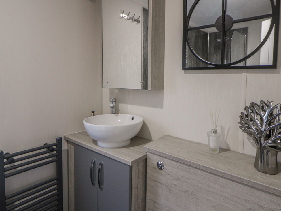 A bathroom with a wash basin and mirror at The Ridgeway in New Quay