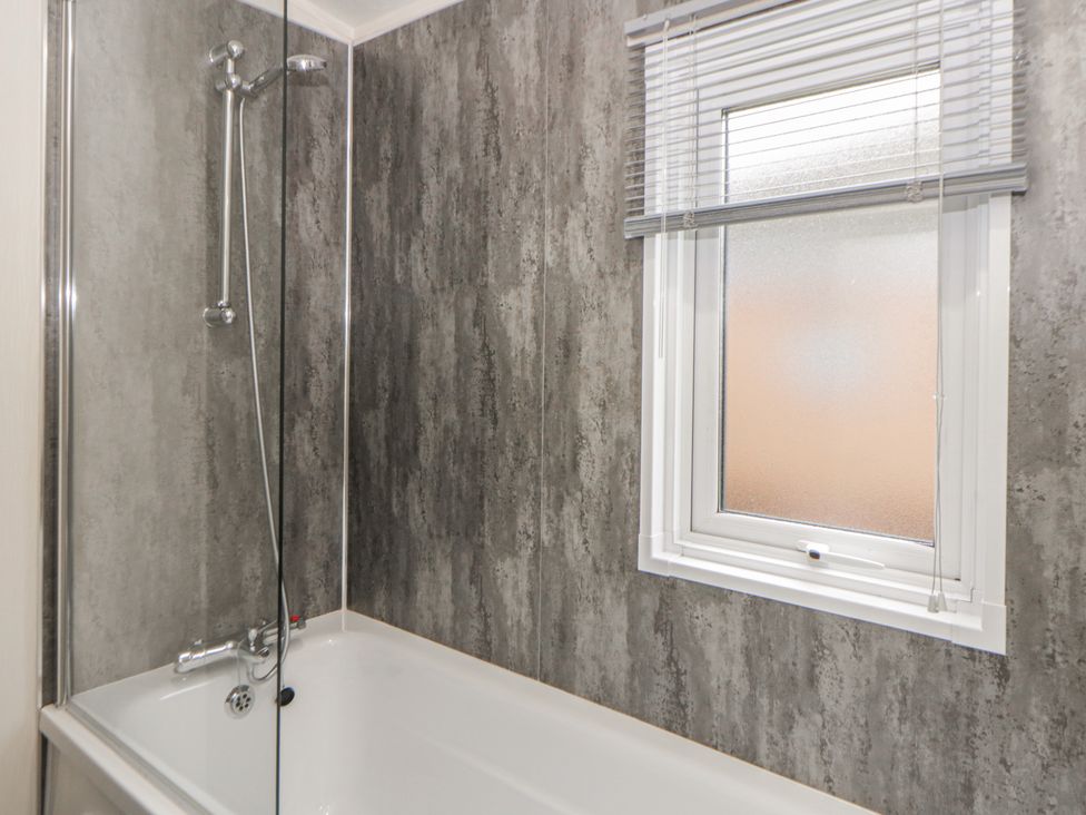 A bathroom with a shower and bathtub at The Ridgeway in New Quay