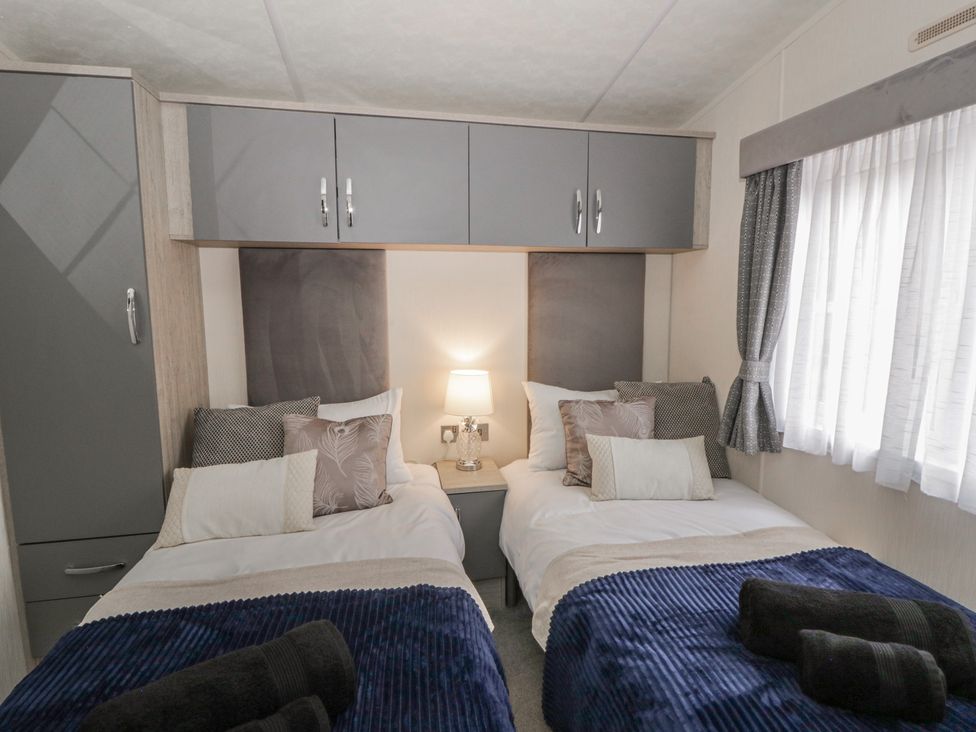 A bedroom with twin beds and a bedside table at The Ridgeway in New Quay