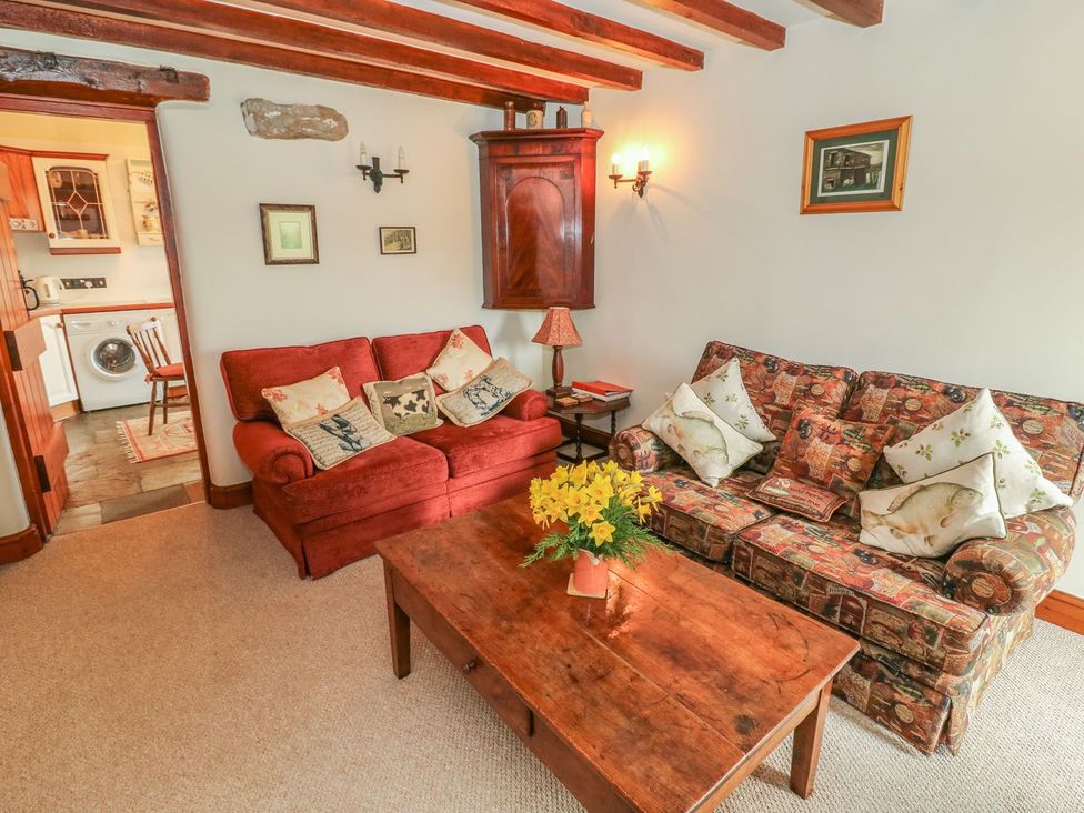 A living room with sofas and a table at The Bothy in Leyburn