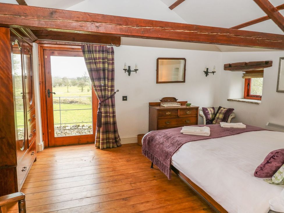 A bedroom with a bed and door leading outside at The Bothy in Leyburn