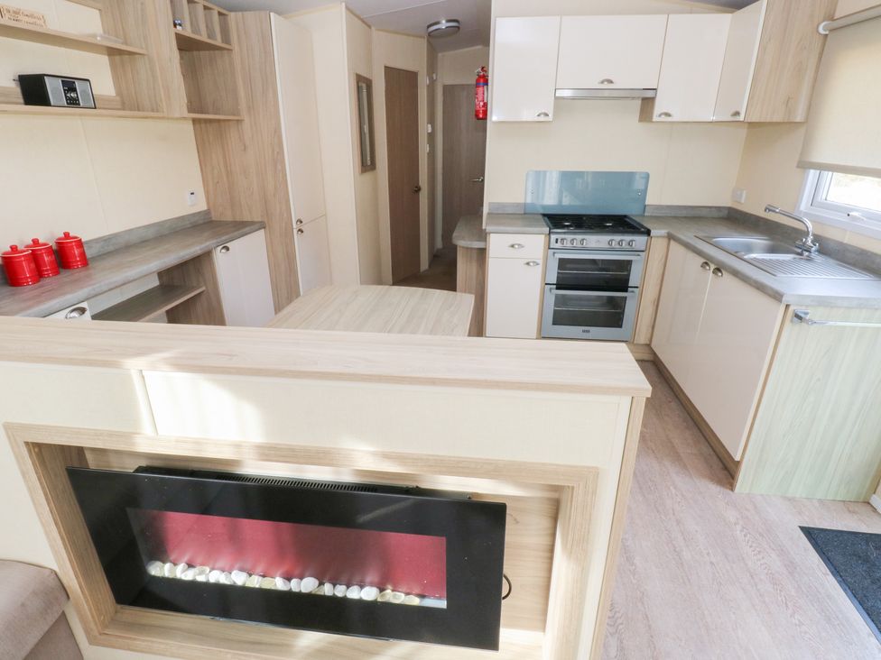 A kitchen with a stove and sink at Under cliff caravan in Ferryside